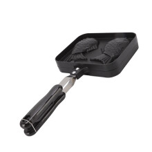 Doublesided, nonstick coated Taiyaki pan maker in fish shape for waffle preparation in the kitchen with open flame