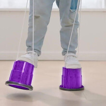 Pernas de pau para equilíbrio infantil, com alças de nylon ajustáveis e base de plástico reforçado com almofada de borracha antiderrapante.