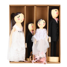 Ensemble de poupées vintage en bois représentant un couple de mariés, avec des robes typiques et des détails multicolores peints. Poupée en