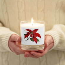 Kerze im eleganten Glasgefäß mit einem Pointsettia-Motiv