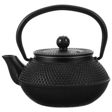 Tetera pequeña de hierro fundido negro estilo vintage con asa para preparar té en casa.