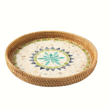 Plateau rond bohème en rotin avec panier décoratif multicolore pour décorer la table et y disposer café, pain, aliments et fruits.