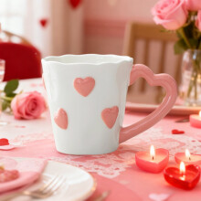 Keramische mok voor Valentijnsdag met roze hartjesmotief.