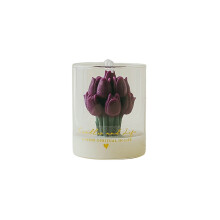 Vela aromática con forma de tulipán en frasco de vidrio.