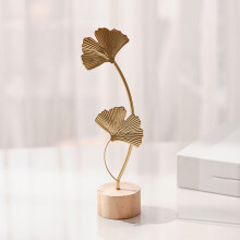 Decorazione in ferro a forma di foglia di ginkgo dorata con base in legno.