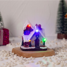 Décoration de Noël lumineuse en résine représentant une maison de village, idéale pour les fêtes.