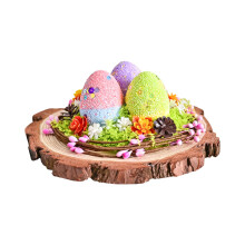 Ovo decorativo de espuma com flores artificiais, pinhas e base de madeira para decoração de mesa sazonal.