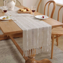 Chemin de table en macramé de lin avec pompons pour une décoration de table bohème dans la salle à manger ou la chambre.