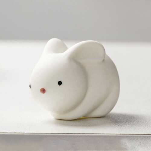 Keramisch konijnenornament, wit, voor op het bureau.