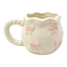 Witte keramische drinkmok met handgemaakt strikpatroon.