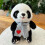 Peluche panda seduto con sciarpa e dettaglio a forma di cuore 1