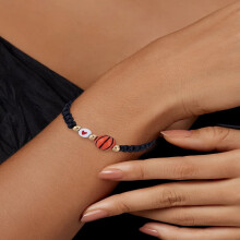 Pulsera de baloncesto en acrílico negro con detalles metálicos dorados.