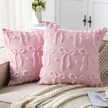 Almofada de veludo rosa em formato de coração com detalhe de fita.