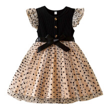 Vestido de verão infantil sem mangas com estampa de bolinhas, modelo mini, gola redonda, fechamento com botões e detalhes em patchwork.