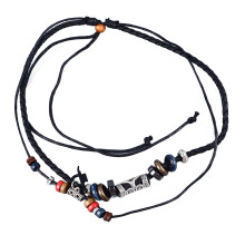 Ciondolo in stile tribale con perline di legno o decorazioni turchesi, con funzione di allontanare gli spiriti maligni, in pelle nera intrecciata a