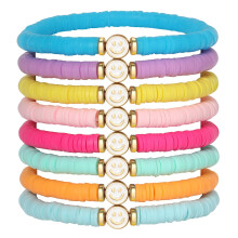 7-delige armbandenset van witgoud met bedeltjes in de vorm van een lachend hartje of sterretje.