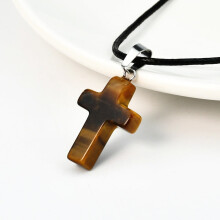 Colar versátil com pingente de cruz em ágata e cordão de couro.