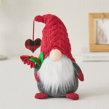 Décoration de Noël : un gnome en peluche avec un bonnet tricoté et un porte-bonheur.