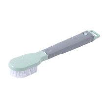 Een groene, stijve plastic schoenborstel met een lange steel.