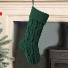 Gebreide groene kerstsok als decoratie voor de open haard