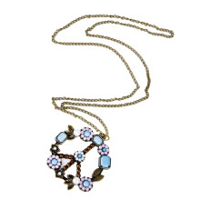 Modieuze ketting met hanger in de vorm van een donkere parel en vredessymbool.