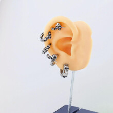 Oorring met doodskopdesign en helix-effect, gemaakt van roestvrij staal.