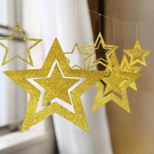 Décorations pour sapin de Noël : Étoiles en carton brillant, creuses et évidées, qui scintillent comme le ciel nocturne.