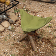 Tabouret triangulaire portable en toile imperméable pour le camping.