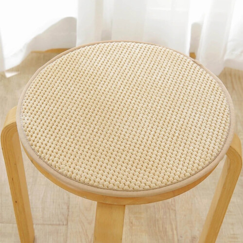 Almofada de assento circular bege com borda quadrada para uso interno.