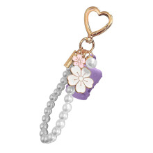 Llavero con soporte para bálsamo labial con clip y detalles de perlas, práctico y seguro para sujetar llaves y bolsos.