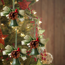 Sapin de Noël décoré de cloches, de nœuds et de pommes de pin