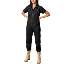 Tuta corta da donna stile utility, nera, a maniche corte, con cerniera.
