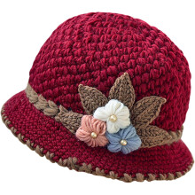 Gebreide damesmuts in Franse stijl met gehaakte bloemen.