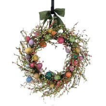 Ghirlanda primaverile per la porta d'ingresso con uova di Pasqua e decorazioni di fiori selvatici.