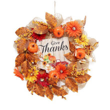 Ghirlanda autunnale colorata con vere zucche, pigne, foglie d'acero, bacche e decorazioni per la porta del Ringraziamento.