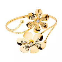 Bracelete ajustável dourado com estampa de borboleta e flor para a parte superior do braço.
