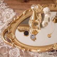 Plateau de toilette ovale vintage doré en miroir, idéal pour le maquillage et les desserts.