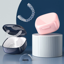Reisvriendelijke bewaarcontainer voor kunstgebitten, geschikt voor het reinigen en opbergen van aligners, roze met geventileerd deksel.