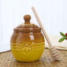 ceramic vintage honey storage jar with wooden stirring stick